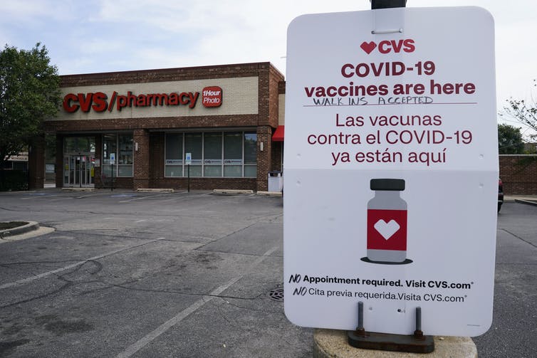 A sign outside of a pharmacy saying vaccines are available for walk-in appointments.
