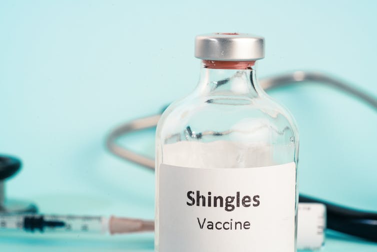 Close-up of Shingles vaccine with syringe in background.