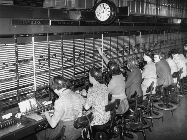 seated operators in front of telephone switchboard