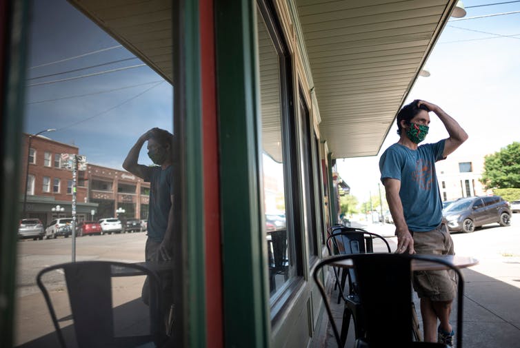 A cafe owner wears a protective face mask in Stillwater, Oklahoma.