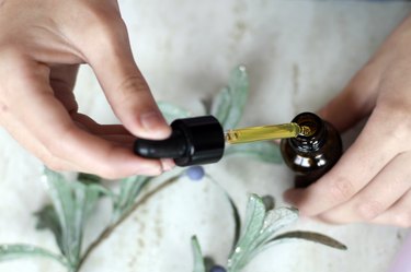 Hands holding pipette of essential oil