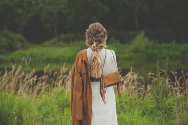 Romantic woman with suede jacket and handbag outdoor