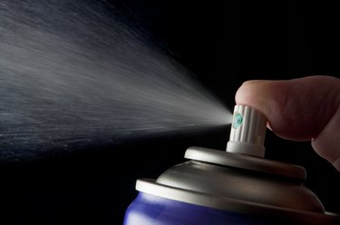Spraying aerosol can isolated in black