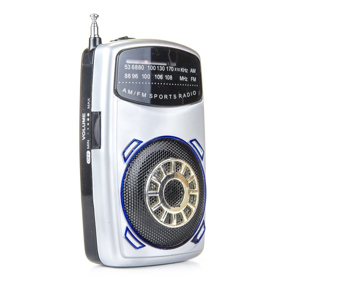 Old and small transistor radio on battery on the white