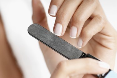 Close-up of a woman's hand filing her nails