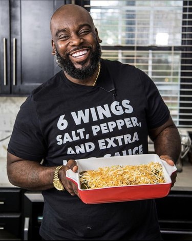 Darius holding a dish filled with food