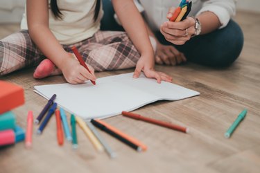 Woman And Girl Drawing On Hardwood Floor