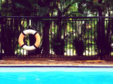 Life ring hanging on fence by swimming pool