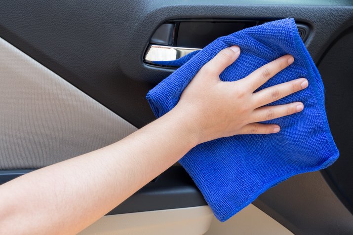 Cropped Hand Of Woman Wiping Car With Blue Towel