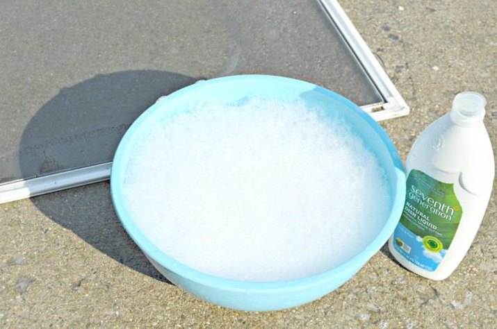 Clean window screen with bucket of soapy water