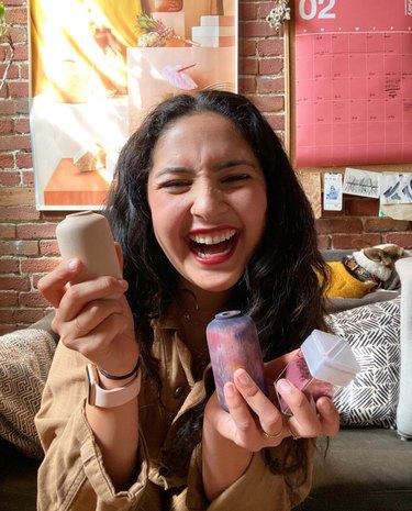 Laughing woman holds a variety of wooden vases