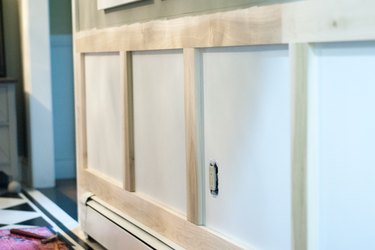 Attach vertical one-by-fours to the wall