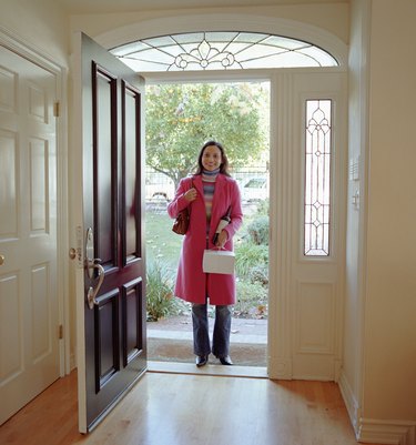 Woman standing at front door, holding pastry box