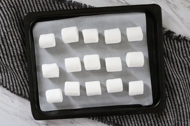 Place marshmallows on parchment paper