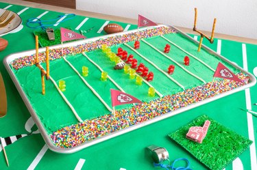 DIY stadium cake on table with whistles and foam finger