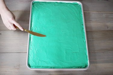 Frosting sheet pan cake with green icing