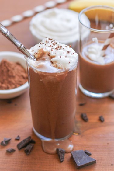 Overflowing chocolate shake in a glass with whipped cream