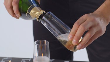 Pour champagne into flutes.