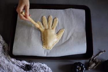 Brushing severed hand pie with egg wash