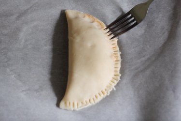 Crimping edges of calzone with fork