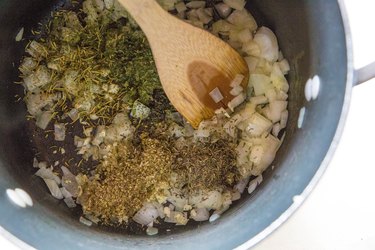 onion, garlic, and herbs in a stock pot