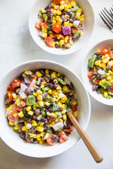 Fresh corn salad in a bowl with two serving bowls