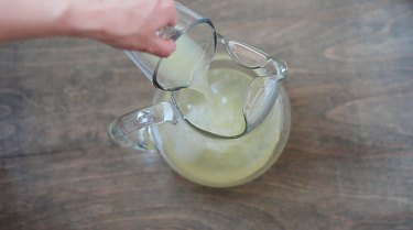 Pouring lemon juice into pitcher