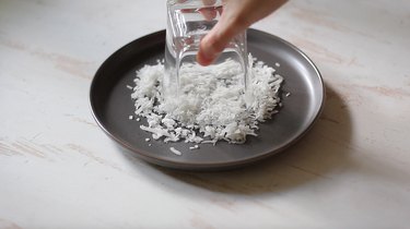 Dipping rim of glass into coconut flakes