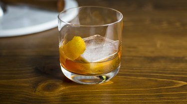 An Old Fashioned cocktail on a wood table