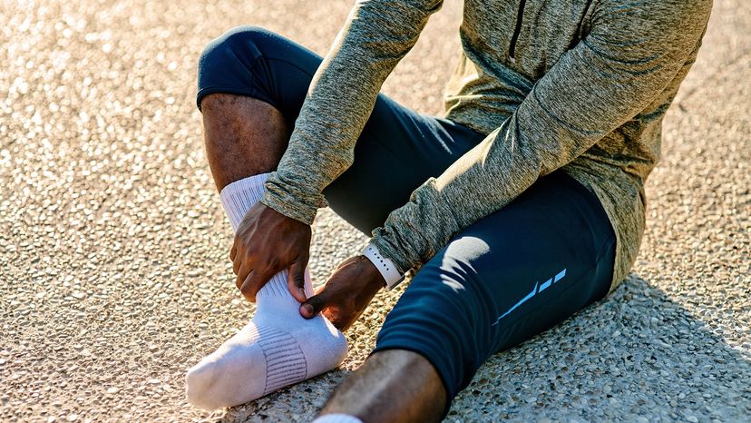 runner looking at foot in socks