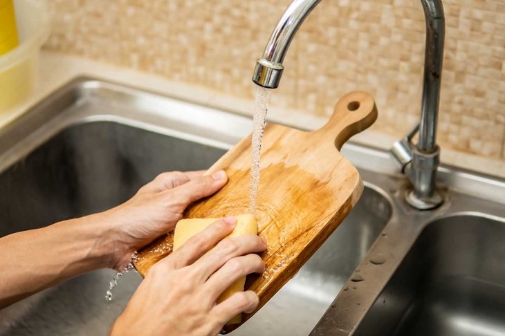 Cleaning wood cutting board in kitchen sink