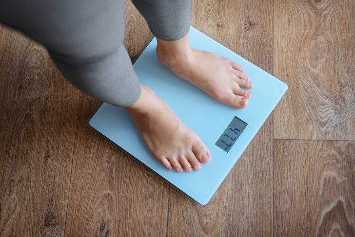 Female bare feet standing on a scales