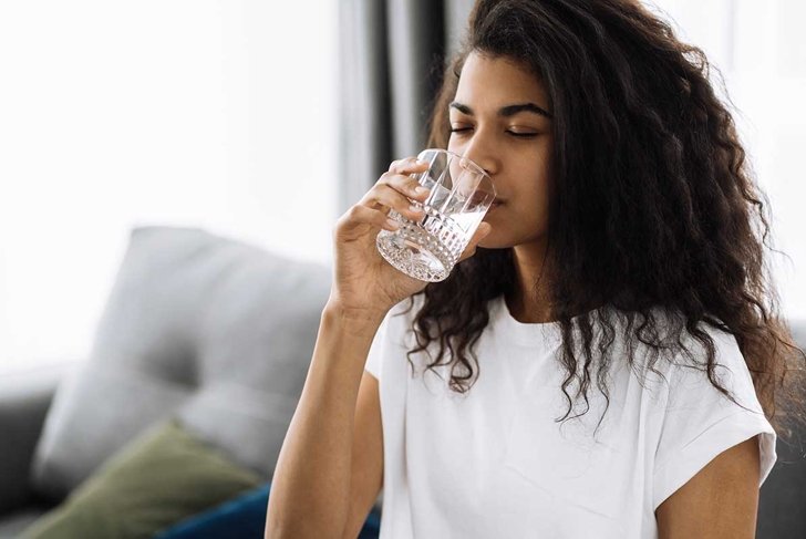 Beautiful girl follow healthy lifestyle, drinking a pure water. African american woman drink daily amount of clean water, healthy lifestyle concept
