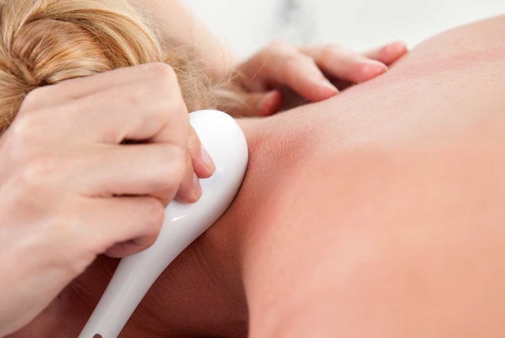 Woman receiving gua sha treatment on neck