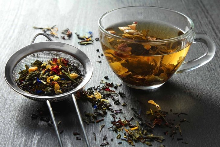 Brewed delicious herbal tea on a wooden black background